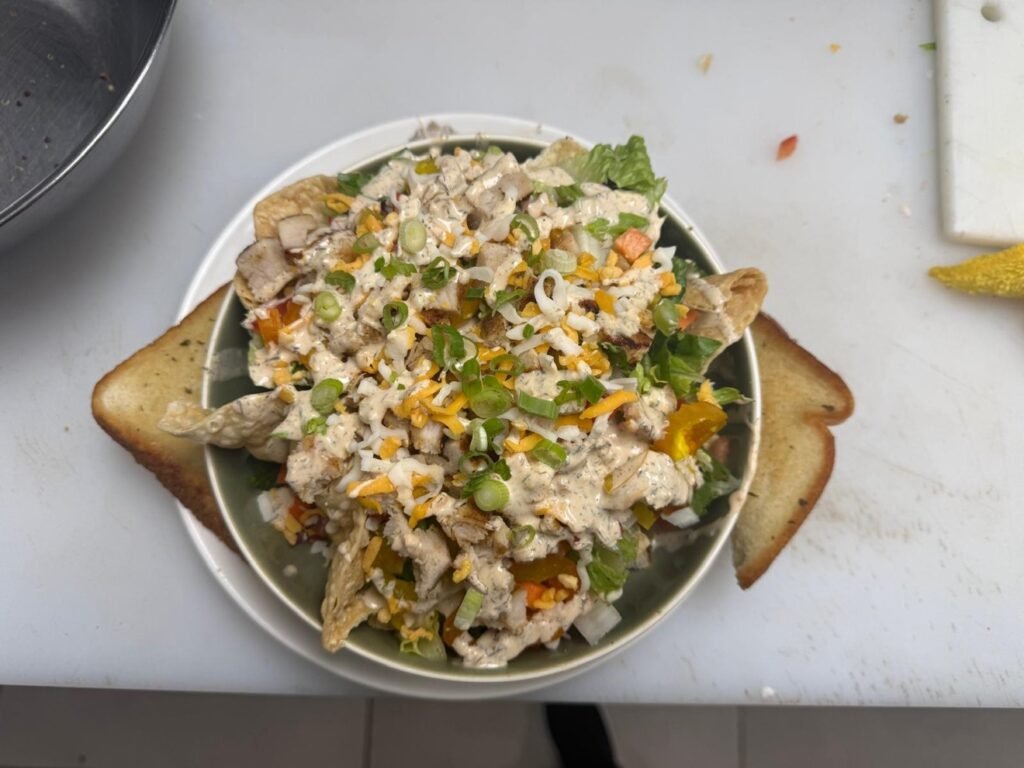 Loaded salad bowl with grilled chicken, cheese, crispy strips and garlic toast at Cravings and Delight, a family restaurant near Paisley Edmonton