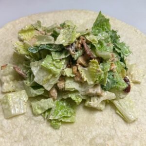 Chicken Caesar wrap filling on an open tortilla at Cravings and Delight