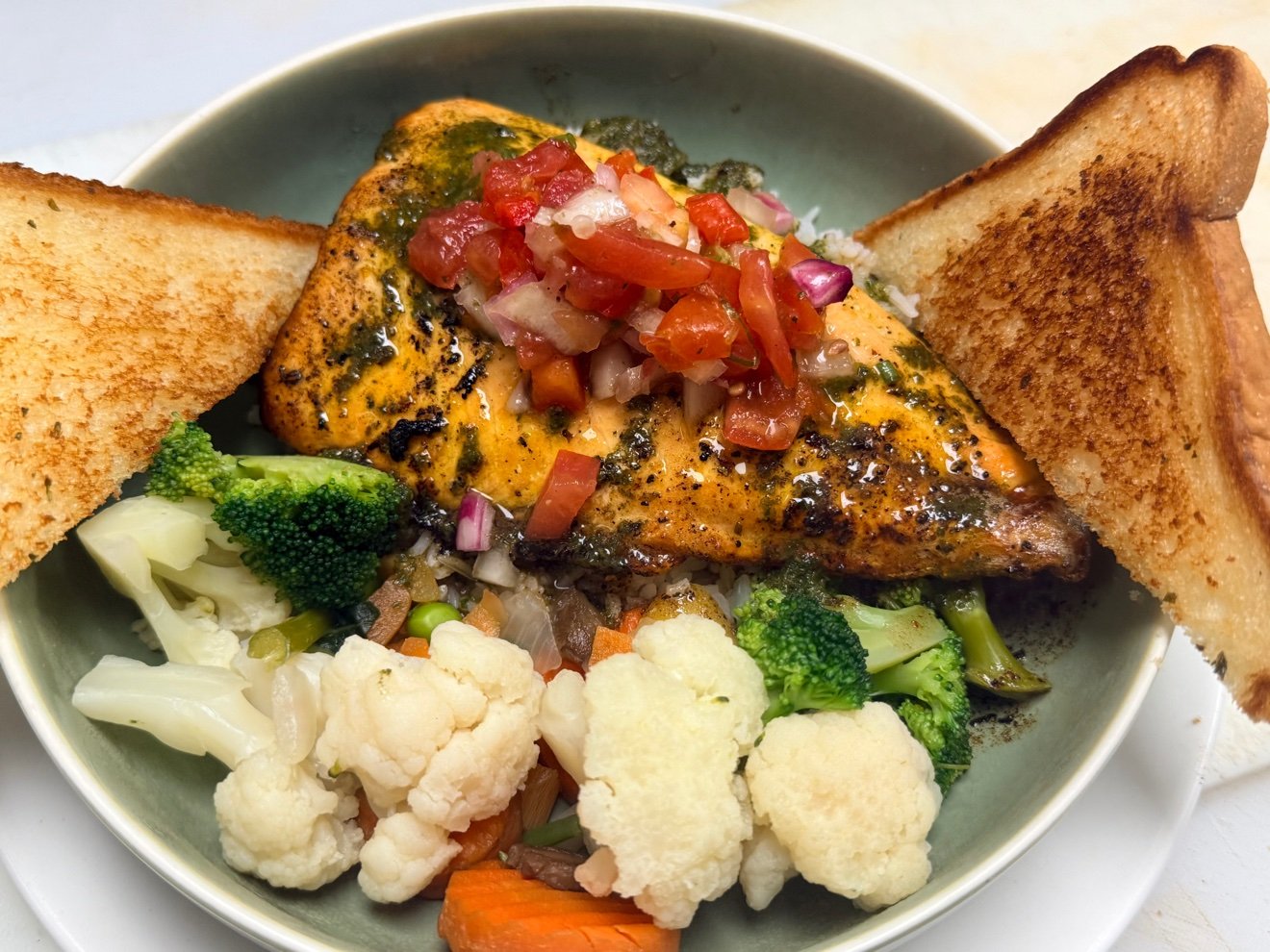 Arctic Char fillet with tomato salsa over rice, vegetables and garlic toast at Cravings and Delight