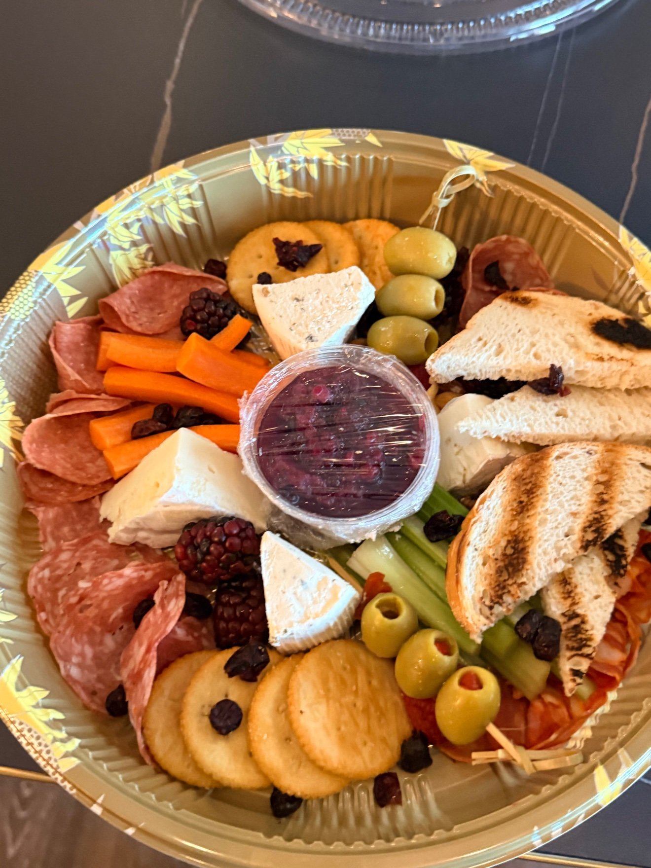 Charcuterie platter with cured meats, cheese, olives, crackers and grilled bread at Cravings and Delight
