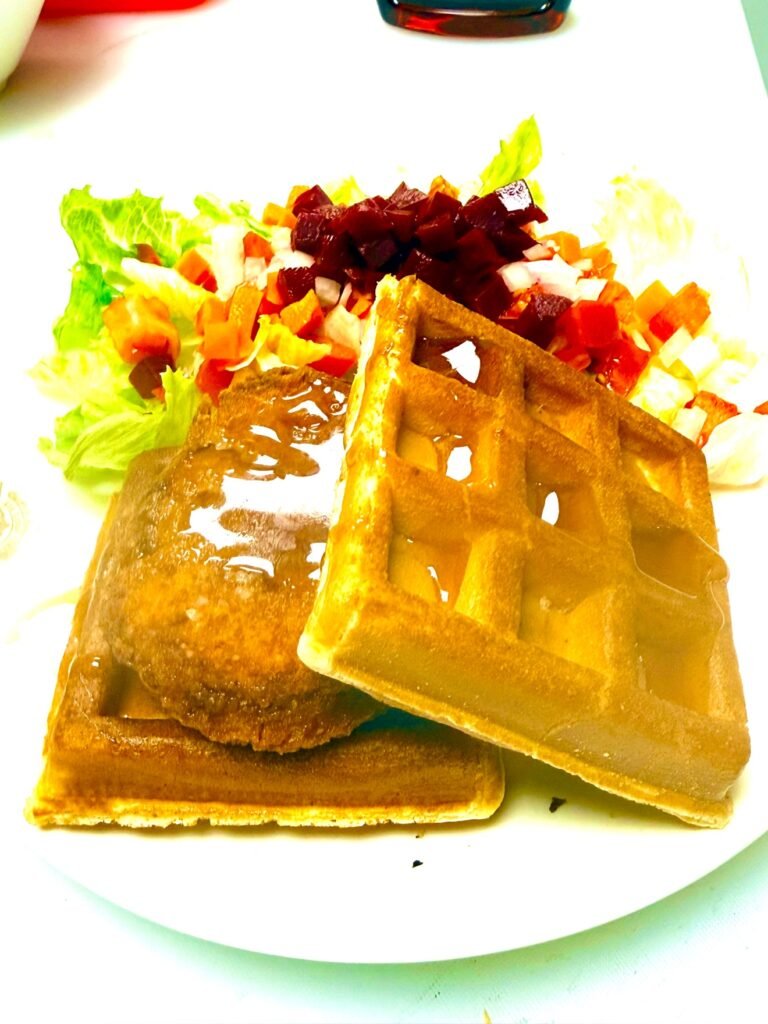 Chicken and waffles with a side salad at Cravings and Delight, a breakfast restaurant near Windermere Edmonton